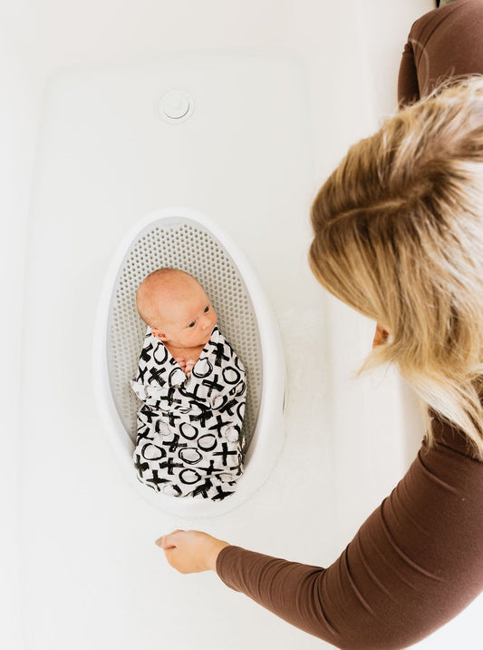 Baby sitting in the bath with water.